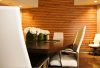 interior of Copperwing Design by Marshall Design Group, a wooden table with white chairs in front of a wooden wall